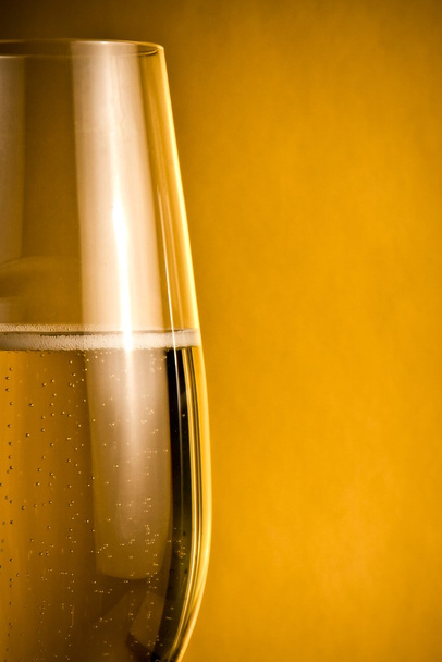 half glass of champagne with golden bubbles - Φωτογραφία, εικόνα