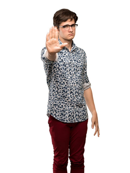 Homme adolescent avec chemise à fleurs et lunettes faire arrêter geste niant une situation qui pense mal sur fond blanc isolé
 - Photo, image