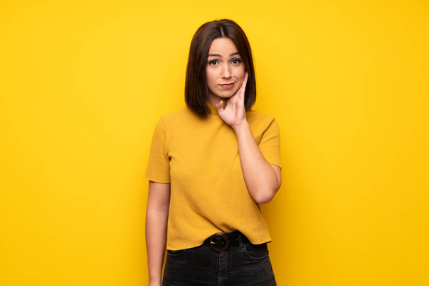 junge Frau über gelbe Wand nachdenkend - Foto, Bild