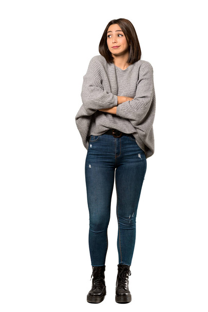 A full-length shot of a Young woman making doubts gesture while lifting the shoulders over isolated white background - Foto, imagen