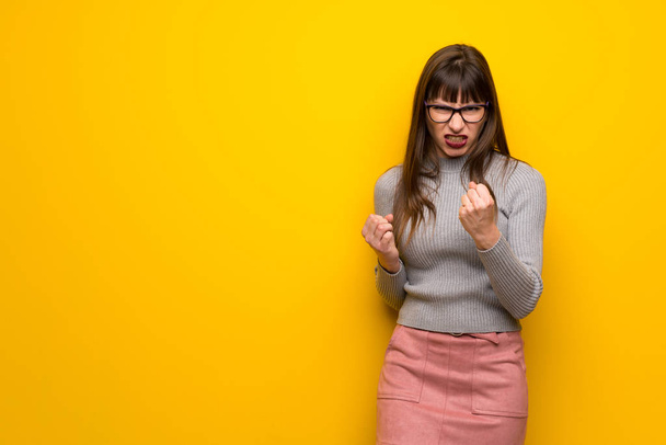 Женщина в очках на желтой стене расстроена плохой ситуацией
 - Фото, изображение