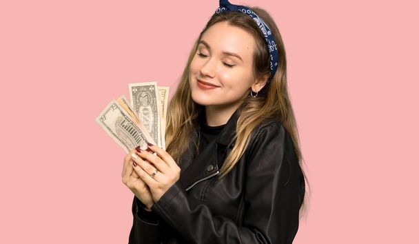 Дівчина-підліток зі шкіряною курткою бере багато грошей на ізольований рожевий фон
 - Фото, зображення