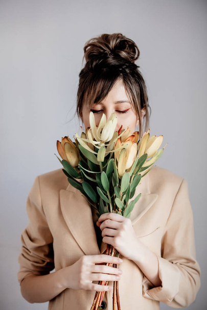 Young woman with bouquet of  Leucadendron - 写真・画像