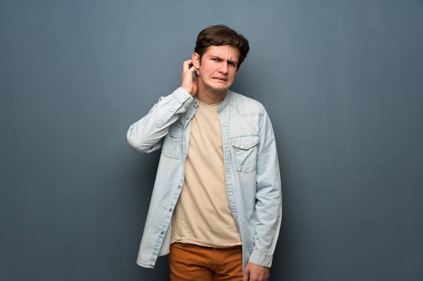 Homme adolescent avec veste en jean sur le mur gris ayant des doutes
 - Photo, image