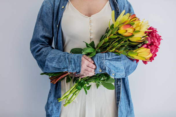 Female hands holding bouquet of peonies and  Leucadendron - Fotografie, Obrázek