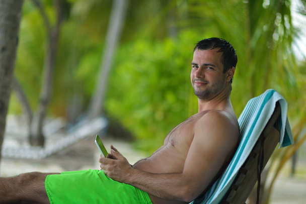 man ralaxing and use tablet at beach - Foto, afbeelding