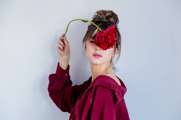 Vrouw in rood shirt holing rode peony - Foto, afbeelding