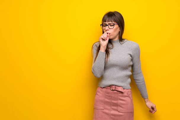 Woman with glasses over yellow wall is suffering with cough and feeling bad - Photo, Image