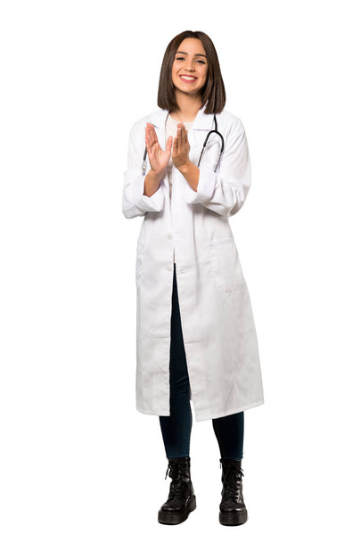 Een full-length schot van een jonge dokter vrouw applaudisseren na de presentatie in een conferentie over geïsoleerde witte achtergrond - Foto, afbeelding