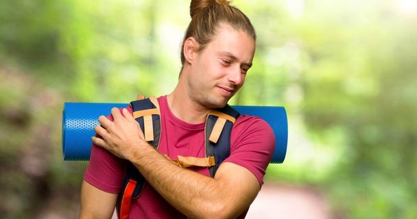 Uomo escursionista con zaino in spalla che soffre di dolore alla spalla per aver fatto uno sforzo in montagna
 - Foto, immagini