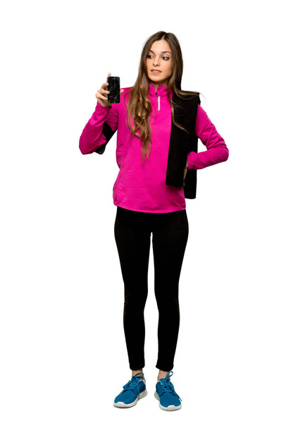 Prise de vue complète de Jeune femme sportive avec une tenue troublée smartphone cassé sur fond blanc isolé
 - Photo, image
