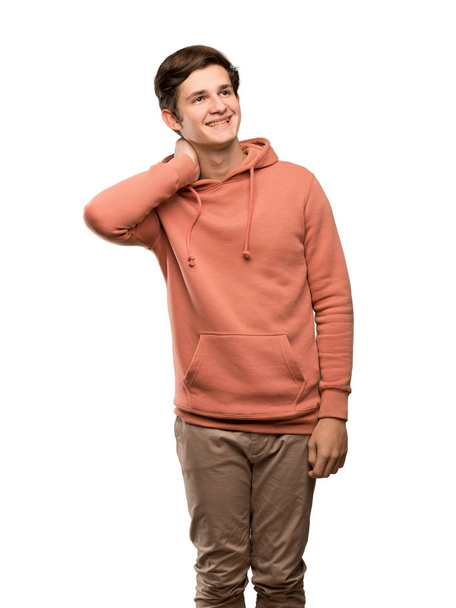 Adolescent homme avec sweat-shirt penser une idée tout en grattant la tête sur fond blanc isolé
 - Photo, image