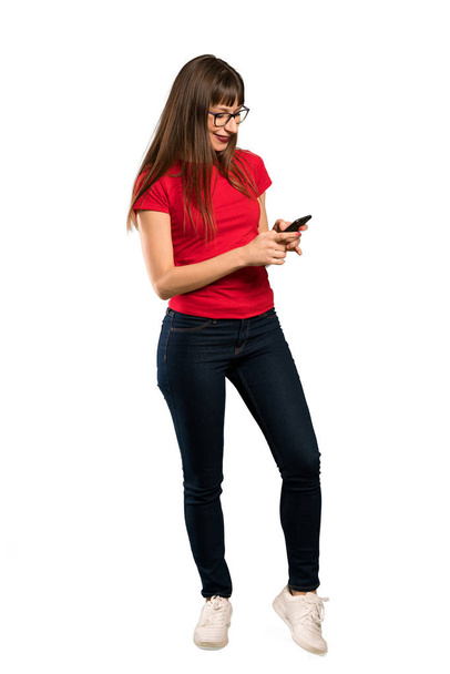 Full-length shot of Woman with glasses sending a message with the mobile - Foto, Bild