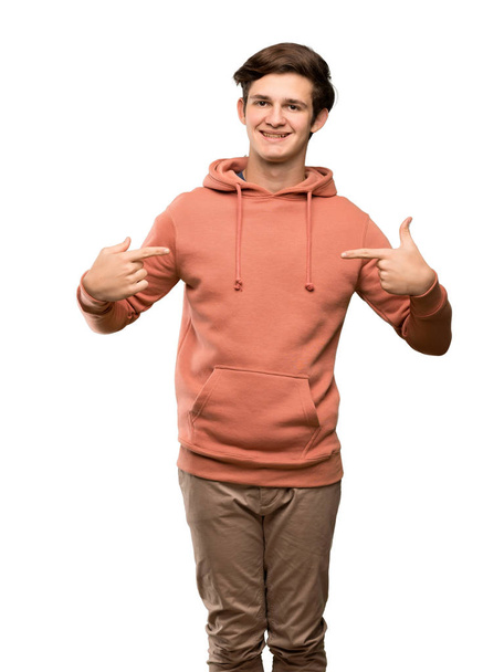 Teenager man with sweatshirt proud and self-satisfied over isolated white background - Foto, Imagen