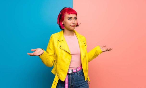 Young woman with yellow jacket unhappy and frustrated with something because not understand something - Foto, imagen