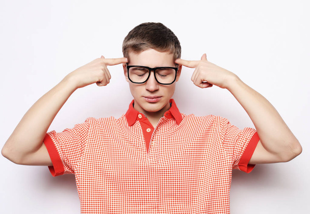 young man with glasses closed ears - Foto, afbeelding