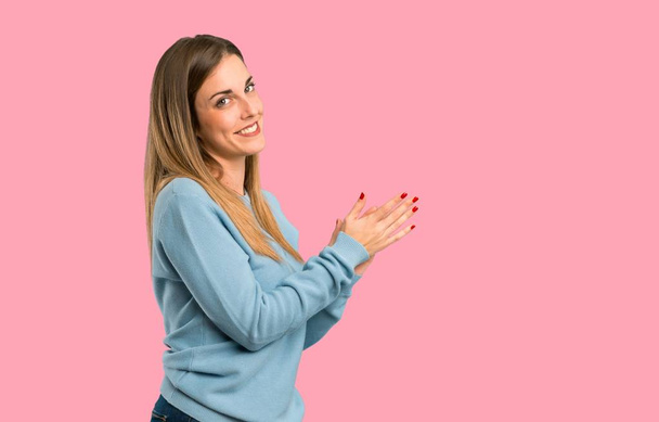 Blonde woman with blue shirt applauding after presentation in a conference on isolated pink background - Foto, Imagem