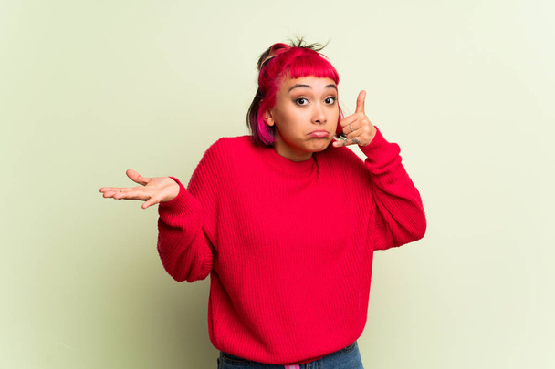 junge Frau mit rotem Pullover überrascht und macht Handygeste - Foto, Bild