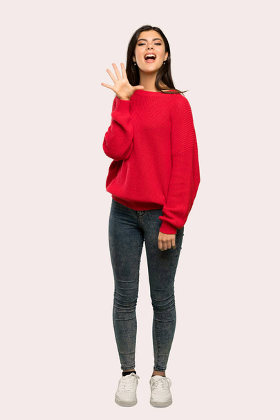Uma foto completa de uma adolescente com camisola vermelha contando cinco dedos sobre fundo isolado
 - Foto, Imagem