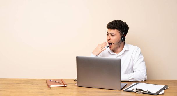 Telemarketer man yawning and covering wide open mouth with hand - Photo, image