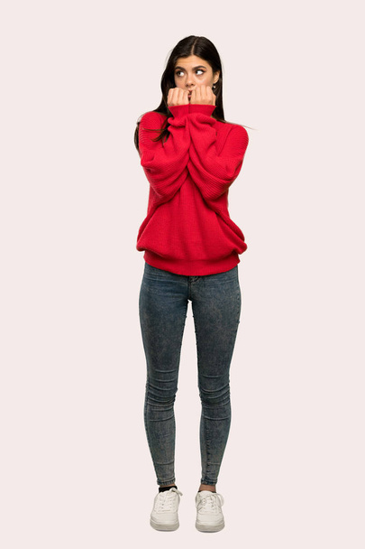 Täyspitkä kuva teini tyttö punainen pusero hermostunut ja peloissaan laittaa kädet suuhun yli eristetty tausta
 - Valokuva, kuva