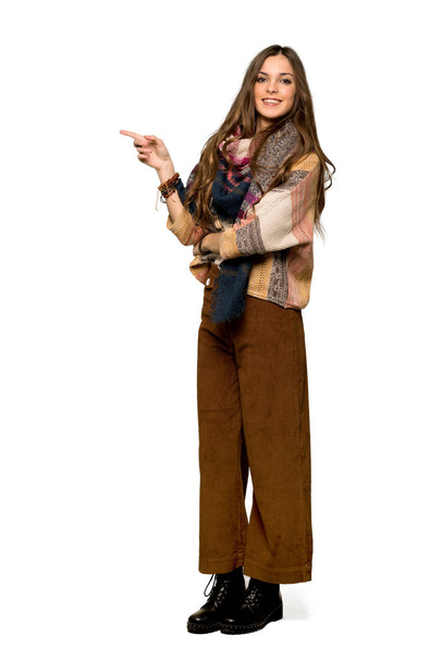 Plan complet de Jeune femme hippie pointant du doigt sur le côté en position latérale sur fond blanc isolé
 - Photo, image