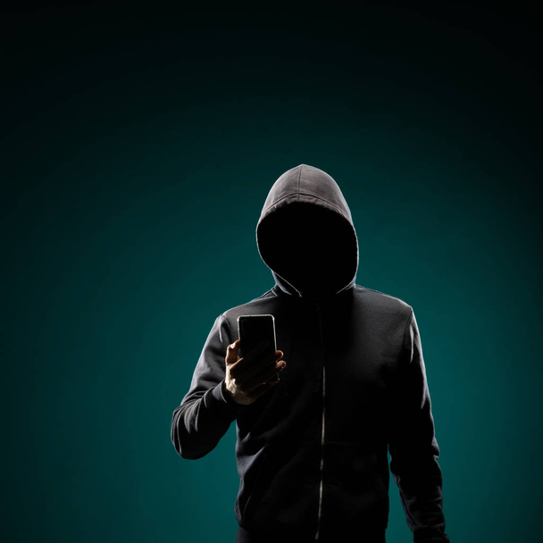 Retrato de hacker de computador com capuz. Cara escura obcecada. Ladrão de dados, fraude na internet, darknet e conceito de segurança cibernética
. - Foto, Imagem