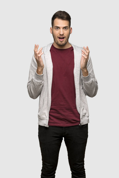 Чоловік з светром з шокованим виразом обличчя на сірому фоні
 - Фото, зображення