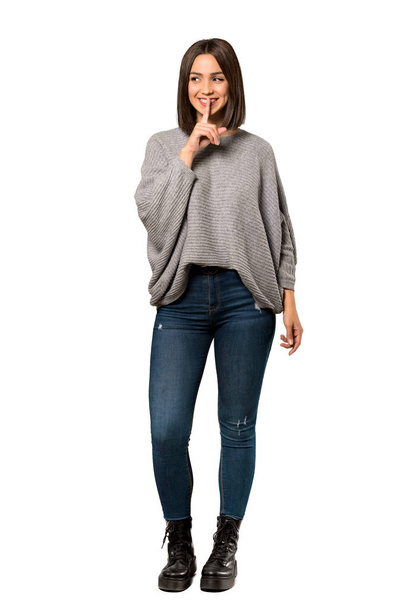 A full-length shot of a Young woman showing a sign of silence gesture over isolated white background - 写真・画像