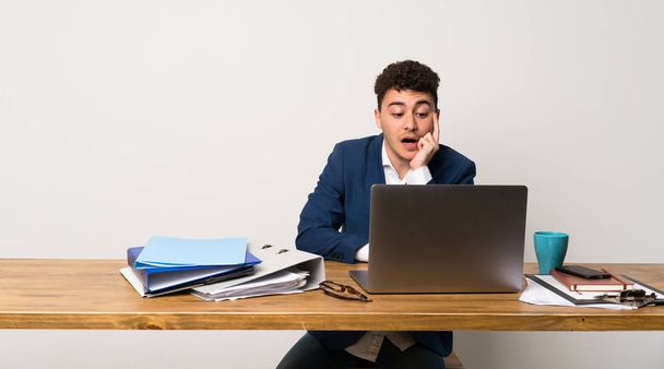 Άνθρωπος των επιχειρήσεων σε ένα γραφείο έκπληκτος και σοκαρισμένος ενώ ψάχνει δεξιά - Φωτογραφία, εικόνα