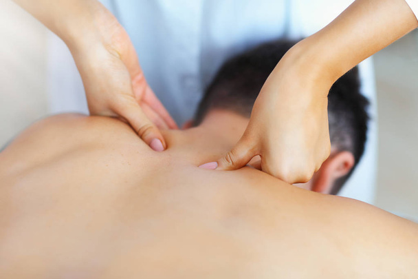 Handsome man having massage in spa salon - Photo, image