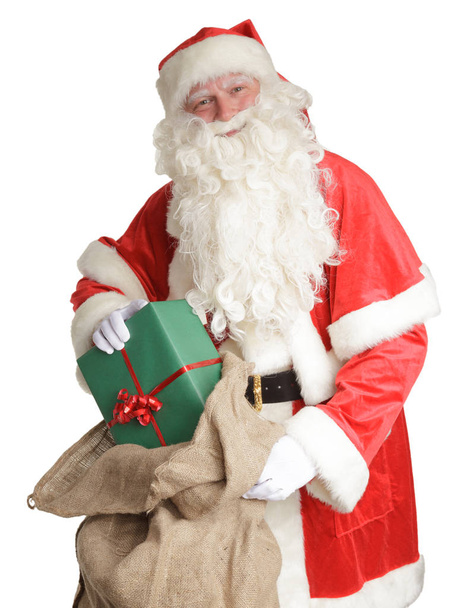 Santa Claus bagging gift into sack - Fotoğraf, Görsel
