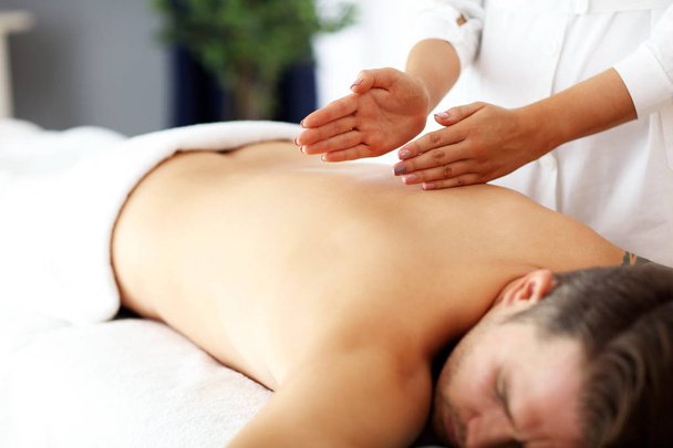 Handsome man having massage in spa salon - Foto, imagen