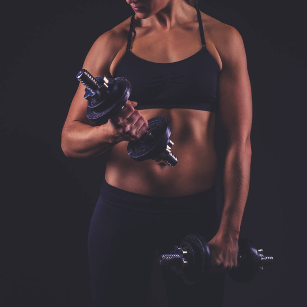 Młoda kobieta sportowy na ciemnym tle - Zdjęcie, obraz