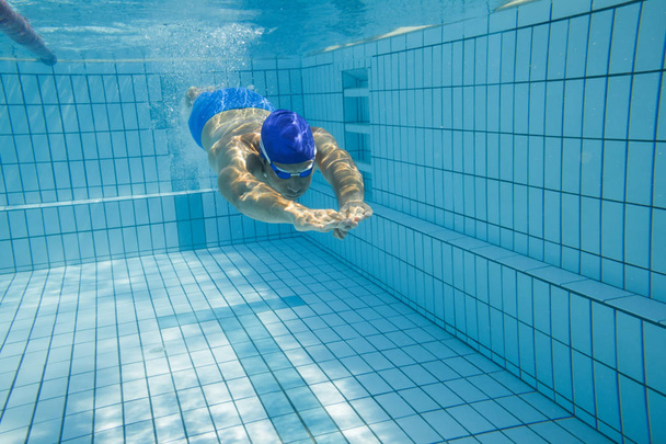 Young man swimming in pool - Фото, зображення