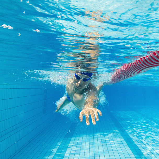 Young man swimming in pool - Valokuva, kuva