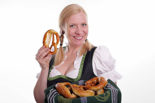 Young woman in traditional bavarian costume holding pretzels - Zdjęcie, obraz