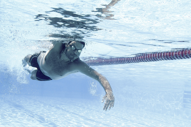 Male swimmer in the swimming pool. Underwater photo  - Foto, afbeelding