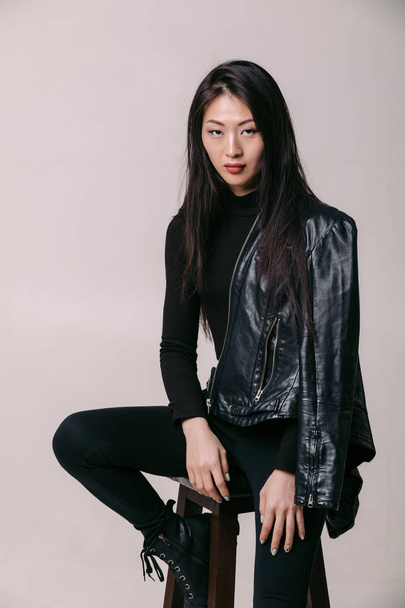 asian model in black jacket posing in studio - Photo, image