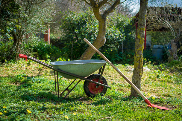 dirty wheelbarrow in a meadow - 写真・画像