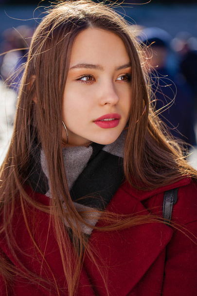 Closeup portrait of a young girl in a burgundy cashmere coat in  - Foto, afbeelding
