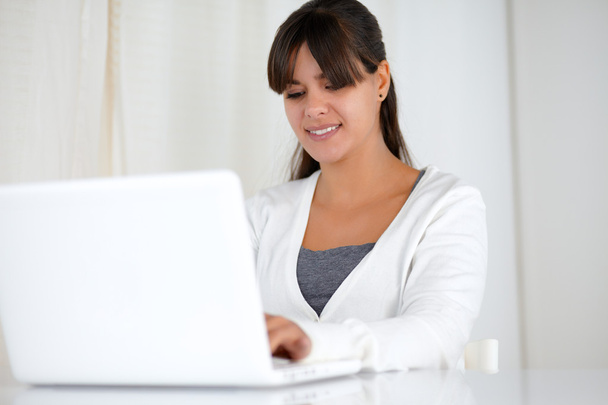 Charming young woman working on laptop computer - Zdjęcie, obraz
