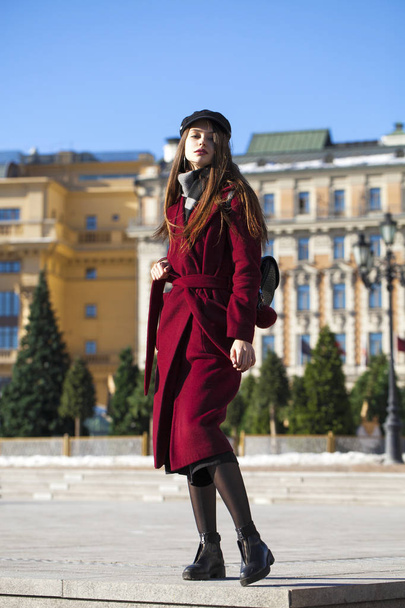 Beautiful girl in stylish in a long burgundy coat - 写真・画像
