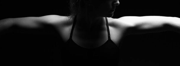 Female bodybuilder posing on dark background - Fotoğraf, Görsel