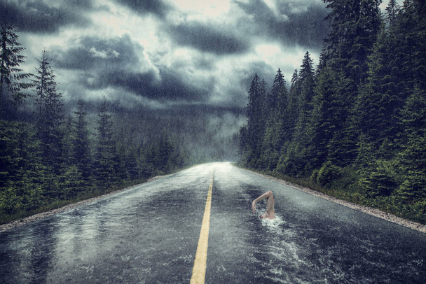 Surreal image with man swimming in asphalt pool - Photo, image