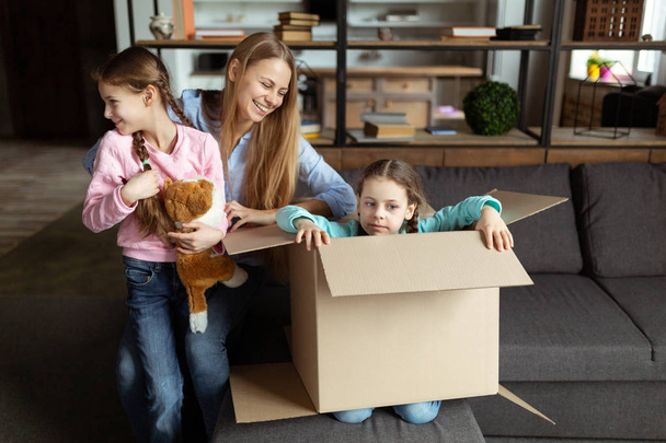 Exited family feeling happy on moving day, cheerful cute daughters enjoying family relocation - Fotografie, Obrázek
