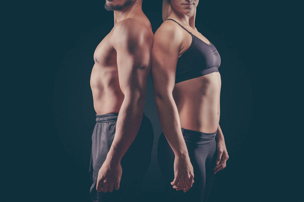 Sporty young couple on dark background - Foto, imagen