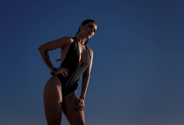 Beautiful athletic girl in a swimsuit on the background of the sea - Fotoğraf, Görsel