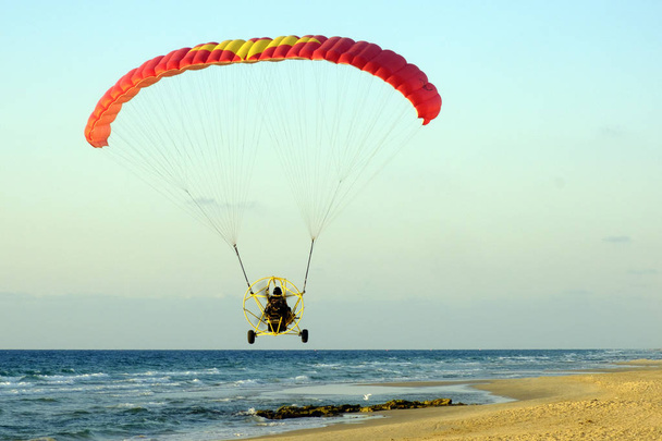 A parachute car flies over the Mediterranean Sea - Photo, Image