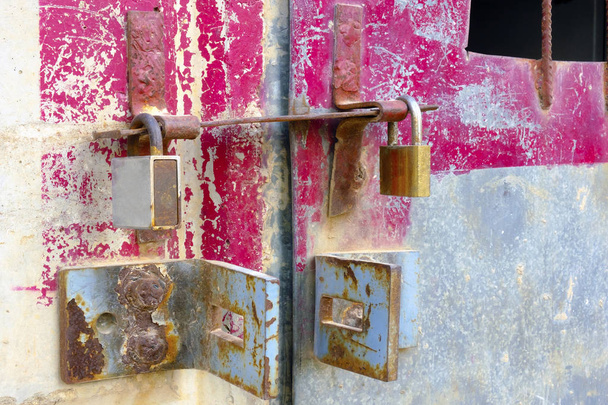 Железные замки на железной двери с большими железными петлями
 - Фото, изображение
